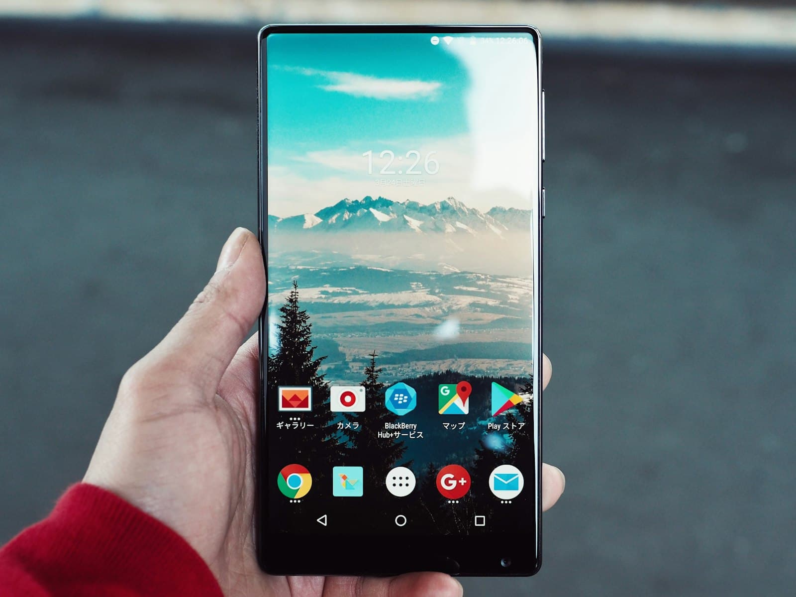 A hand holding an Android phone with the Play Store icon on the home screen